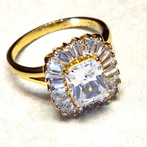 Costume jewelry gold toned ring with faux diamond setting, size unknown